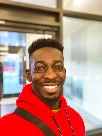 Black male student wearing a red hoodie smiling