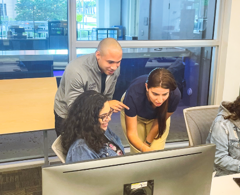 Instructors helping student at computer