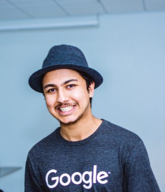 Smiling man of color wearing Google shift and hat