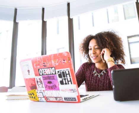 Female student of color sitting in front of laptop with lots of stickers